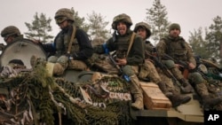 Militares ucranianos viajan en un transportador blindado que se mueve a través de una posición rusa que había sido invadida por las fuerzas ucranianas en las afueras de Kiev, Ucrania, el 31 de marzo de 2022.