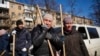 Una mujer llora antes de comenzar a limpiar el sitio donde un bombardeo dañó edificios residenciales en Kiev, Ucrania, el 18 de marzo de 2022.