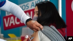 Un trabajador de la salud vacuna a una joven contra el COVID-19 con una dosis donada por Estados Unidos en Quilmes, Argentina, el 3 de agosto de 2021. 