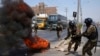 La policía remueve neumáticos incendiados en la Autopista Central durante una protesta en las afueras de Lima, Perú, el 4 de abril de 2022.