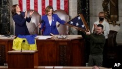 Президент України Володимир Зеленський тримає американський прапор, подарований спікеркою Палати представників США Ненсі Пелосі, Капітолій, Вашингтон, 21 грудня 2022 року