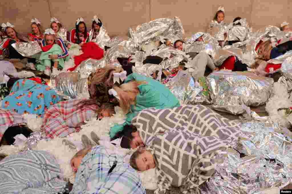 Los miembros de &quot;Spirit of America&quot; descansan debajo de las mantas para mantenerse calientes antes del 96&ordm; Desfile del Día de Acción de Gracias de Macy&#39;s en Manhattan, Nueva York, el 24 de noviembre de 2022.