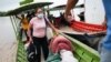 Migrantes venezolanos llegan en canoas a orillas del río Arauca del lado colombiano portando sus pertenencias tras huir de su país por operativos militares, según la agencia colombiana de migración, en Arauquita, el 27 de marzo de 2021.