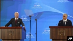 El presidente de Estados Unidos, Joe Biden, a la izquierda, da una conferencia de prensa con el primer ministro de Israel, Yair Lapid, en el hotel Waldorf Astoria de Jerusalén, el jueves 14 de julio de 2022. (Atef Safadi/Pool vía AP)