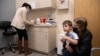Una mujer y su hijo de 3 años duratnte una cita para una dosis de la vacuna de Moderna contra el COVID-19 en un ensayo en Commack, Nueva York el 30 de noviembre de 2021.