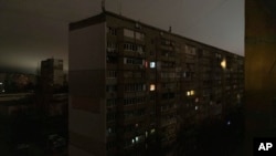 Algunas ventanas de un edificio de apartamentos se ven iluminadas durante un apagón en el centro de Kiev, Ucrania, el lunes 14 de noviembre de 2022. (AP Foto/Andrew Kravchenko)