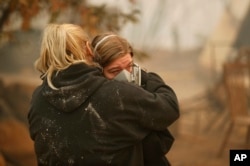 Krystin Harvey (izquierda), consuela a su hija Araya Cipollini delante de los restos de su casa quemada en el incendio Camp Fire, el 10 de noviembre de 2018, en Paradise, California.