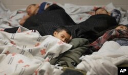 Niños detenidos en la frontera duermen en una celda de retención en una instalación de procesamiento de inmigrantes ilegales en Brownsville, Texas. Junio 18, 2014.