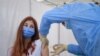 A girl gets a Pfizer BioNTech COVID-19 vaccine in Bucharest, Romania, Wednesday, June 2, 2021. Romania has started the vaccination campaign for children between the ages of 12 and 15. (AP Photo/Andreea Alexandru)