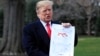 President Donald Trump shows a map of Syria and Iraq showing the presence of the Islamic State in 2017 and 2019, as he speaks to reporters before leaving the White House in Washington, March 20, 2019.