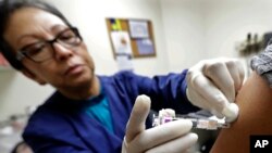 Ana Martinez, una asistente médica del Centro de Salud Comunitario Sea Mar, pone una vacuna contra la gripe a un paciente, en Seattle, Washington. Enero 11, 2018.