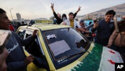 Cidadãos sírios festejam durante o terceiro dia da tomada da cidade pelos insurrectos em Damasco, Síria, terça-feira, 10 de dezembro de 2024.