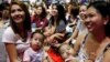 FILE - Filipino mothers hold their babies during a one-minute simultaneous breastfeeding event, as a way to promote breastfeeding, in Manila, Philippines, Aug. 5, 2017. 