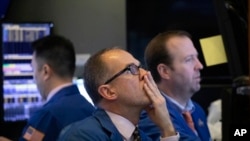 Los operadores monitorean los precios de las acciones en la Bolsa de Nueva York, el jueves 2 de enero de 2020.