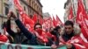 Italian Northern League supporters hold flares as they arrive at political rally led by leader Matteo Salvini, in Milan, Italy, Feb. 24, 2018.