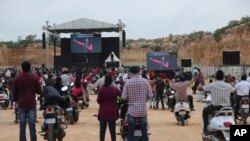 Fieles en vehículos de dos ruedas mantienen el distanciamiento social para evitar la propagación del coronavirus mientras escuchan a un pastor durante una misa en la Iglesia Bethel AG en Bengaluru, India. Junio 21, 2020.