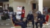 Zambian police sits at the Civic Center in Lusaka, Zambia, as election volunteers carry ballot boxes, September 22, 2011.