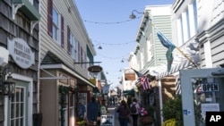 ARCHIVO - Gente camina frente a las tiendas el 13 de noviembre de 2020 en Rehoboth Beach, Delaware, EEUU.