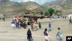 En esta imagen tomada de un video de la Agencia Estatal de Noticias Bakhtar, los combatientes talibanes aseguran un helicóptero del gobierno para evacuar a los heridos en el distrito de Gayan, provincia de Paktika, Afganistán, el miércoles 22 de junio de 2022.