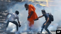 Los manifestantes reaccionan después de que la policía disparara gases lacrimógenos para dispersarlos en Colombo, Sri Lanka, el 9 de julio de 2022. Los manifestantes de Sri Lanka que exigían la renuncia del presidente Gotabaya Rajapaksa. 