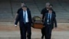 Agentes de la policía federal de Brasil cargan restos humanos recuperados que se cree son del experto indígena brasileño Bruno Pereira y el reportero británico Dom Phillips, el jueves 16 de junio de 2022, en el hangar de la Policía Federal, en Brasilia, Brasil.