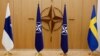 ARCHIVO - Las banderas de Finlandia, la OTAN y Suecia se ven durante una ceremonia para marcar la solicitud de membresía de Suecia y Finlandia en Bruselas, Bélgica, el 18 de mayo de 2022.