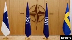 ARCHIVO - Las banderas de Finlandia, la OTAN y Suecia se ven durante una ceremonia para marcar la solicitud de membresía de Suecia y Finlandia en Bruselas, Bélgica, el 18 de mayo de 2022.