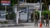 Custodios en la entrada principal del Hospital Naval en Guayaquil, donde fue llevado el exvicepresidente Jorge Glas el 8 de abril de 2024. Glas enfermó en una prisión tras su arresto durante una redada de la policía en la embajada de México en Quito.