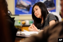 FILE - Sally Kim takes notes during a class in Columbia, Mo. The Common Core approach to math has its critics, who say the method only complicates the subject.
