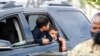 Josué Moreno y su hermano Javier esperan a que miembros de la Guardia Nacional de Washington entreguen a su familia una ración de comida. [Archivo]