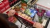 FILE - A shopper pushes a cart of groceries at a supermarket in Bellflower, Calif., on Feb. 13, 2023. 
