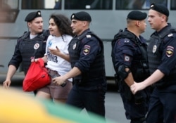 Police officers detain a supporter of Russian investigative journalist Ivan Golunov during a march in Moscow, Russia, Wednesday, June 12, 2019.