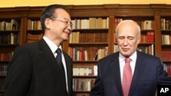 Greek President Karolos Papoulias,right, shows the way to Chinese Prime Minister Wen Jiabao prior their meeting in Athens, on Sunday, Oct. 3, 2010.