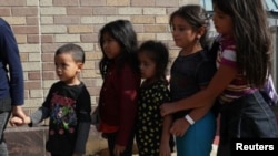 Niños hacen fila mientras familias de migrantes indocumentados son liberadas en una estación de autobuses en McAllen, Texas. 22 de junio, 2018.