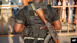 FILE - An Ivory Coast troop member provides security before the arrival of incumbent President Alassane Ouattara at his election rally in Abidjan, Ivory Coast, Oct. 22, 2015.