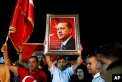 Partidarios del presidente de Turquía, Recep Tayyip Erdogan, escuchan mientras se dirige a ellos fuera de su residencia oficial en Estambul, el domingo 24 de junio de 2018.