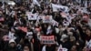 Simpatizantes del destituido presidente surcoreano Yoon Suk Yeol agitan banderas de Corea del Sur frente a una corte que celebró una audiencia el 18 de enero de 2025 para determinar si continúa detenido durante la investigación que se le sigue por declarar la ley marcial.