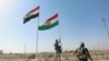 A member of Iraqi security forces takes down the Kurdish flag in Kirkuk, Iraq, Oct. 16, 2017. 