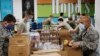 Airman First Class Binh Pham, right, and other members of the Oklahoma Air National Guard fill emergency food boxes at the Regional Food Bank in Oklahoma City, April 23, 2020. 