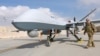 U.S. Air Force officer passes in front of a MQ-9 Reaper drone, one of a squadron that has arrived to step up the fight against the Taliban, at the Kandahar air base, Afghanistan, Jan. 23, 2018. 