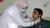 FILE - A pediatrician attends to a boy infected with diphtheria at the al-Sadaqa teaching hospital in the southern port city of Aden, Yemen, Dec. 18, 2017.