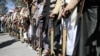 FILE - Houthi supporters hold their wehiapons during a demonstration outside the U.S. Embassy against the United States over its decision to designate the Houthis a foreign terrorist organization, in Sana'a, Yemen, Jan. 18, 2021. 