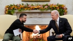 ARCHIVO - El presidente Joe Biden estrecha la mano del presidente ucraniano Volodymyr Zelenskyy mientras se reúnen en la Oficina Oval de la Casa Blanca, el martes 12 de diciembre de 2023, en Washington.