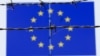 A barbed wire is seen in front of a European Union flag at an immigration reception center in Bicske, Hungary, June 25, 2015. 
