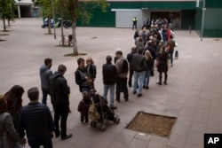 Españoles hacen fila para votar en las elecciones generales del domingo 28 de abril de 2019, en Barcelona.