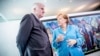 German Chancellor Angela Merkel, right, talks to Interior Minister Horst Seehofer, left, prior to the weekly cabinet meeting at the chancellery in Berlin, June 13, 2018.
