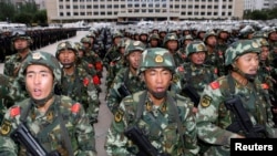 Armed paramilitary policemen stand in formation during a gathering to mobilize security operations in Urumqi, Xinjiang Uighur Autonomous Region, June 29, 2013.