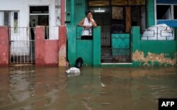 Una mujer mira desde su casa el área inundada de Batabanó, provincia de Mayabeque, Cuba, el 28 de agosto de 2023.