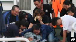Family members cry around the body of Taiwanese fisherman Hung Shih-cheng after his boat, the Kuang Ta Hsing No. 28, arrived at Liuqiu port in Pingtung County, southern Taiwan, May 11, 2013. 