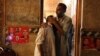 A political party worker comforts another after a suicide attack during an election campaign meeting in Peshawar, Pakistan, July 10, 2018. 